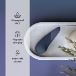 Close-up of Womanizer Vibe showing Pleasure Edges ergonomic shape, Autopilot controls and magnetic USB charging pins in body-safe silicone