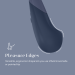 Close-up of Womanizer Vibe showing Pleasure Edges ergonomic shape, Autopilot controls and magnetic USB charging pins in body-safe silicone