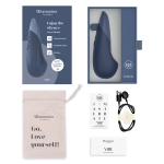 Close-up of the box content of Womanizer Vibe showing Pleasure Edges ergonomic shape, Autopilot controls and magnetic USB charging pins in body-safe silicone